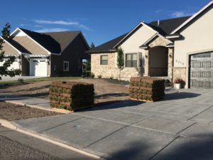 Two pallets of sod in front of a house ready to be installed.